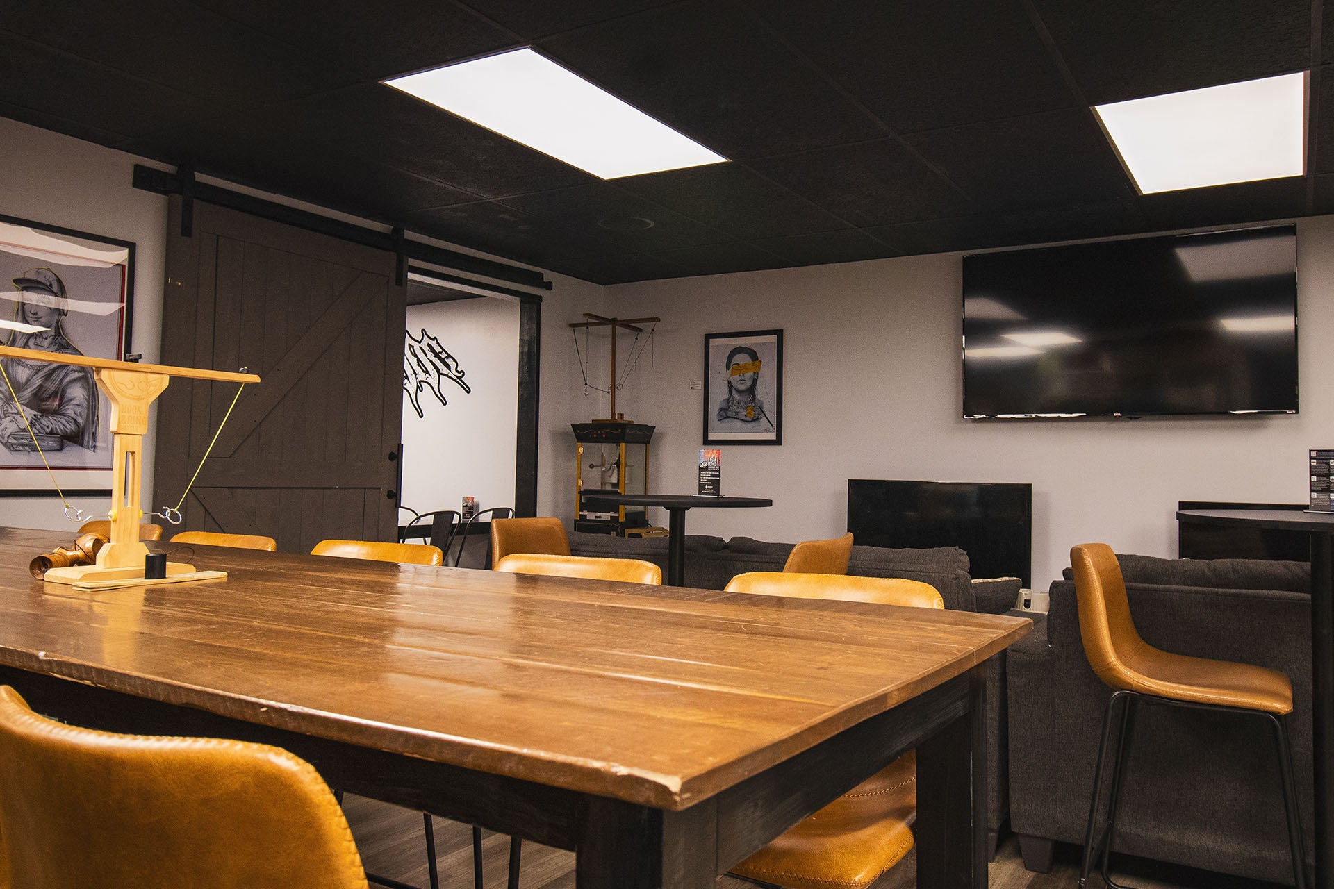 Convict Coffee Co interior with tables, chairs, and a TV on the wall.