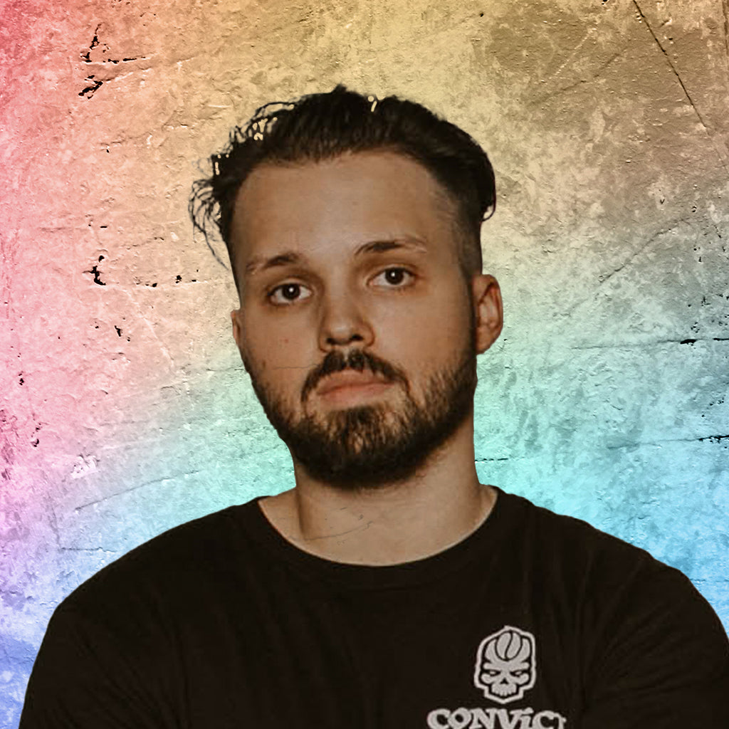 Daniel Klehm wearing a black t-shirt with a logo against a textured, multicolored background