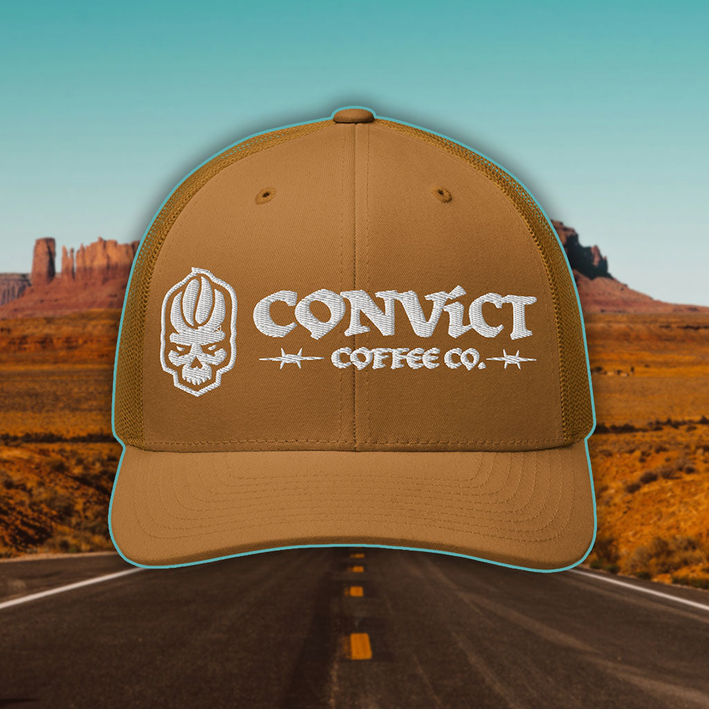 Caramel Trucker Hat with 'Convict Coffee Co.' logo white embroidery on a Desert Road background