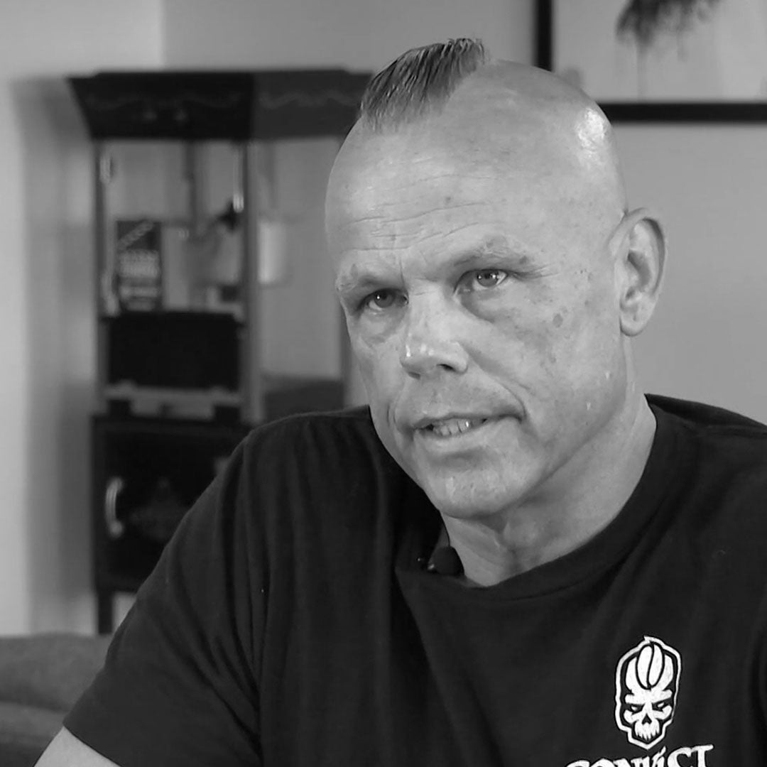 Black and white photo of Dan Klehm wearing a black t-shirt with a logo.