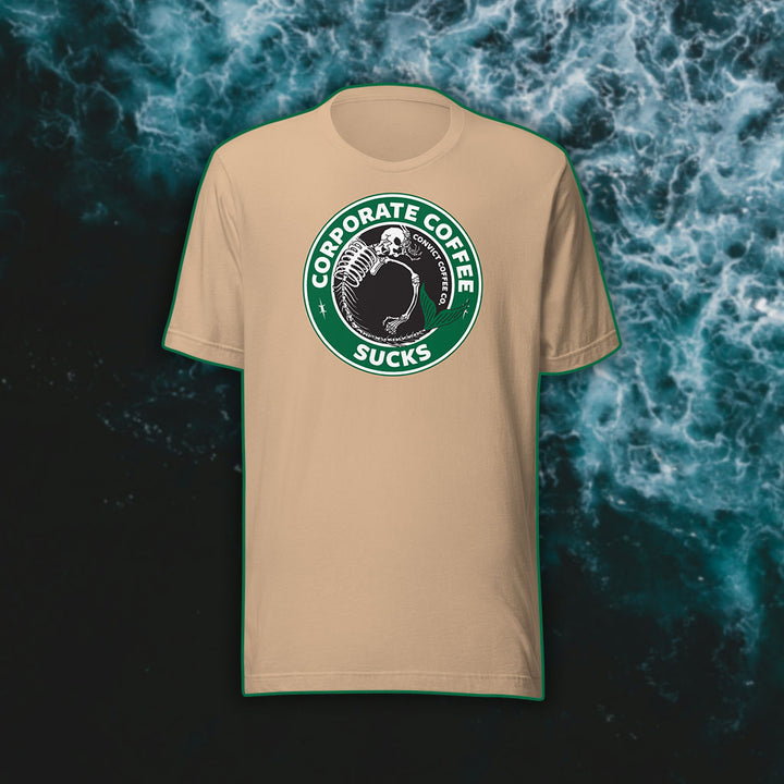 Tan t-shirt with a green, black, and white 'Corporate Coffee Sucks' design with dead mermaid print on a dark water background