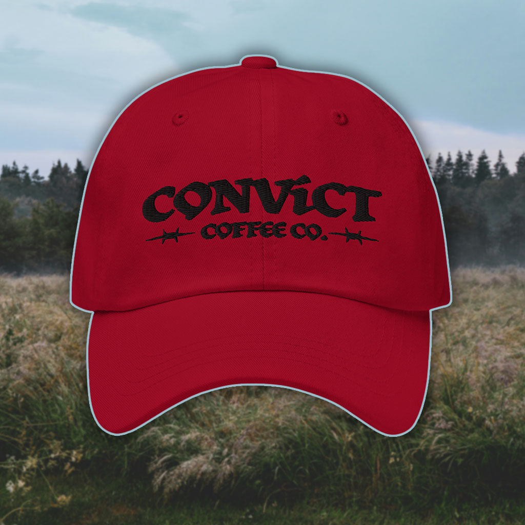 Cranberry Dad Hat with 'Convict Coffee Co.' logo black embroidery on a grassy foggy field background