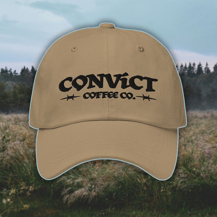 Khaki Dad Hat with 'Convict Coffee Co.' logo black embroidery on a grassy foggy field background