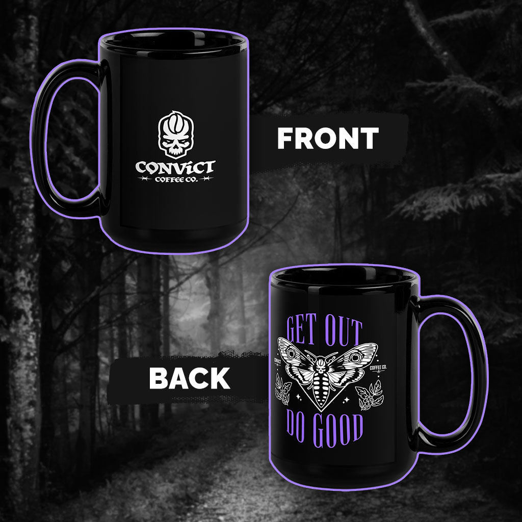 Black Mug with Convict Coffee Co. Logo on Front and Get Out Do Good Design on Back in front of black and white forest background