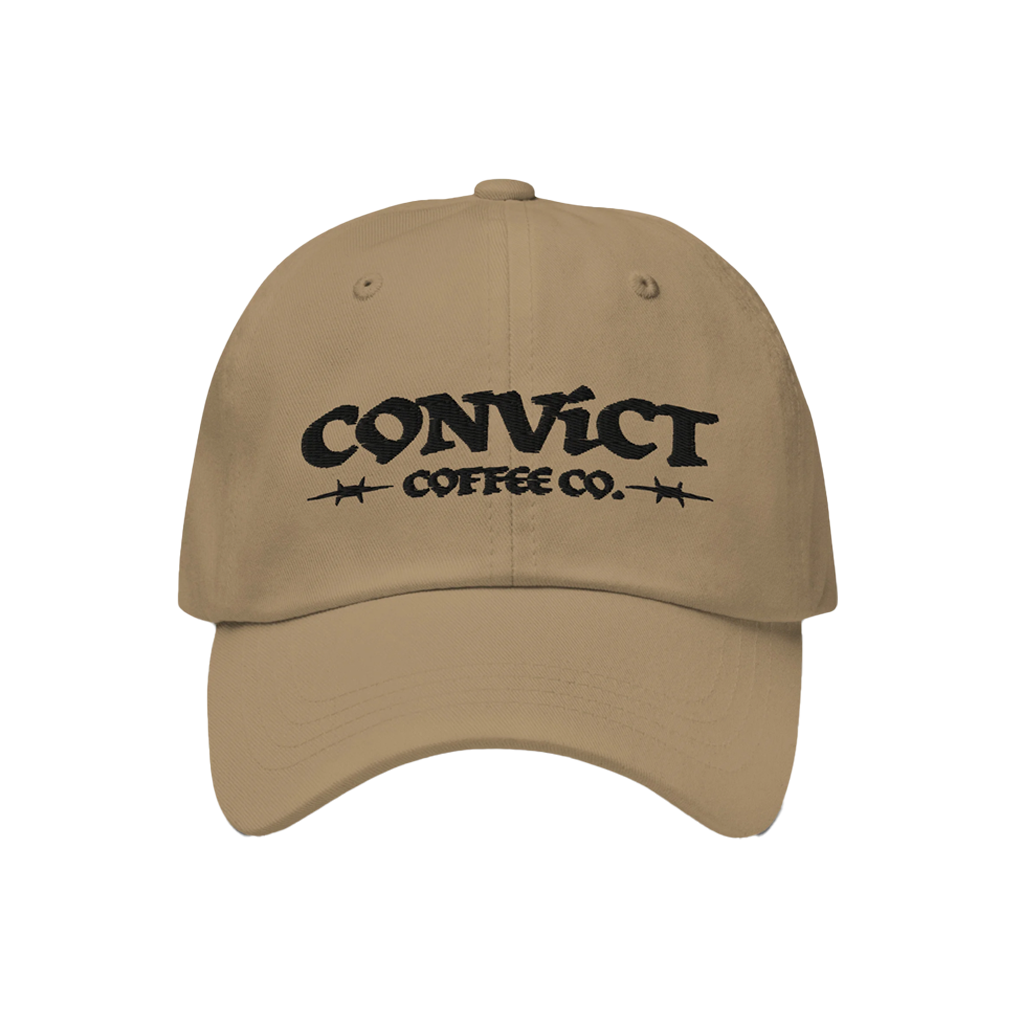Beige cap with 'Convict Coffee Co.' logo in front of white coffee fingerprint branding on transparent background