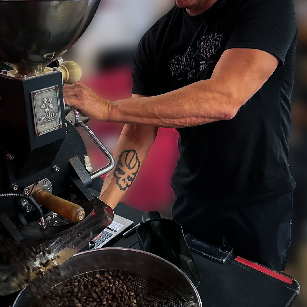 Dan Klehm operating a coffee roasting machine with roasted coffee beans.