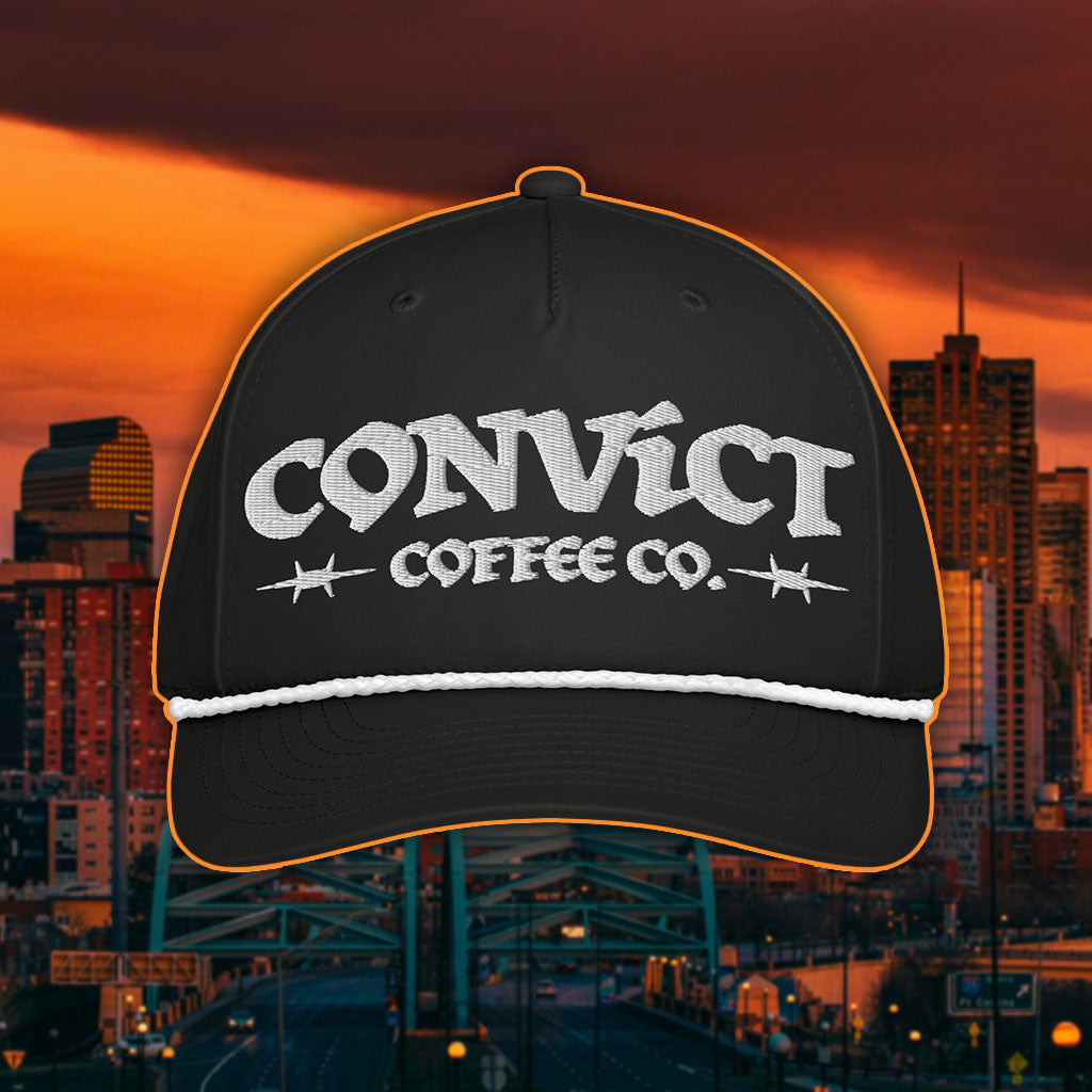 Black Rope Hat with White Rope and 'Convict Coffee Co.' logo white embroidery on a Denver Cityscape Background at Sunset