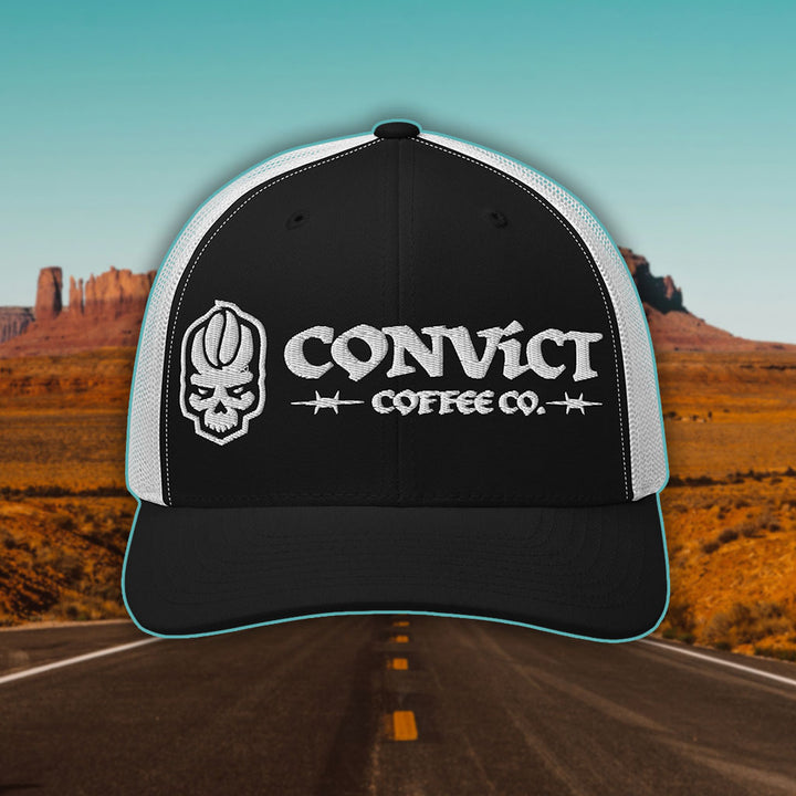 Black and White Trucker Hat with 'Convict Coffee Co.' logo white embroidery on a Desert Road background