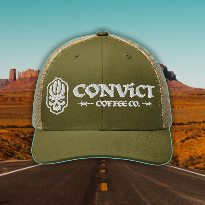 Moss Green and Khaki Trucker Hat with 'Convict Coffee Co.' logo white embroidery on a Desert Road background