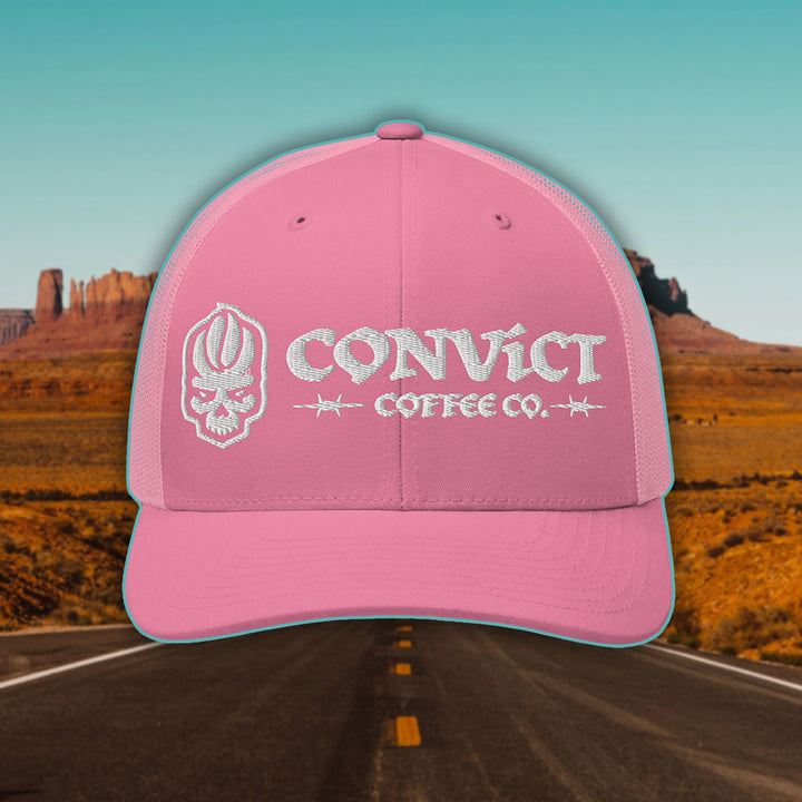 Pink Trucker Hat with 'Convict Coffee Co.' logo white embroidery on a Desert Road background